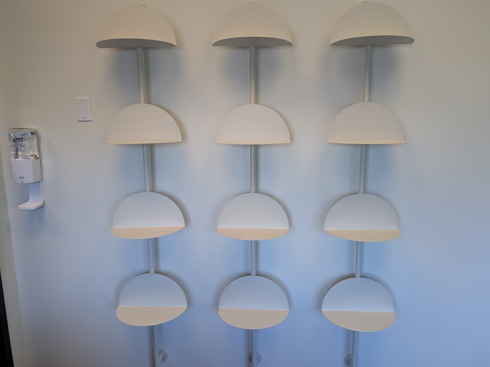 White wall-mounted display shelves arranged in three columns