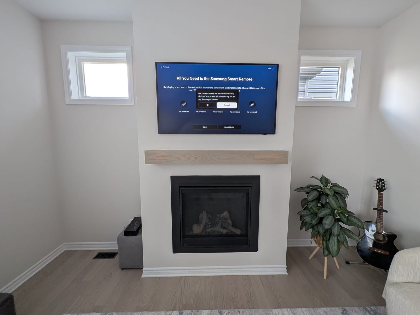 Wall-mounted television above a wooden mantel and fireplace